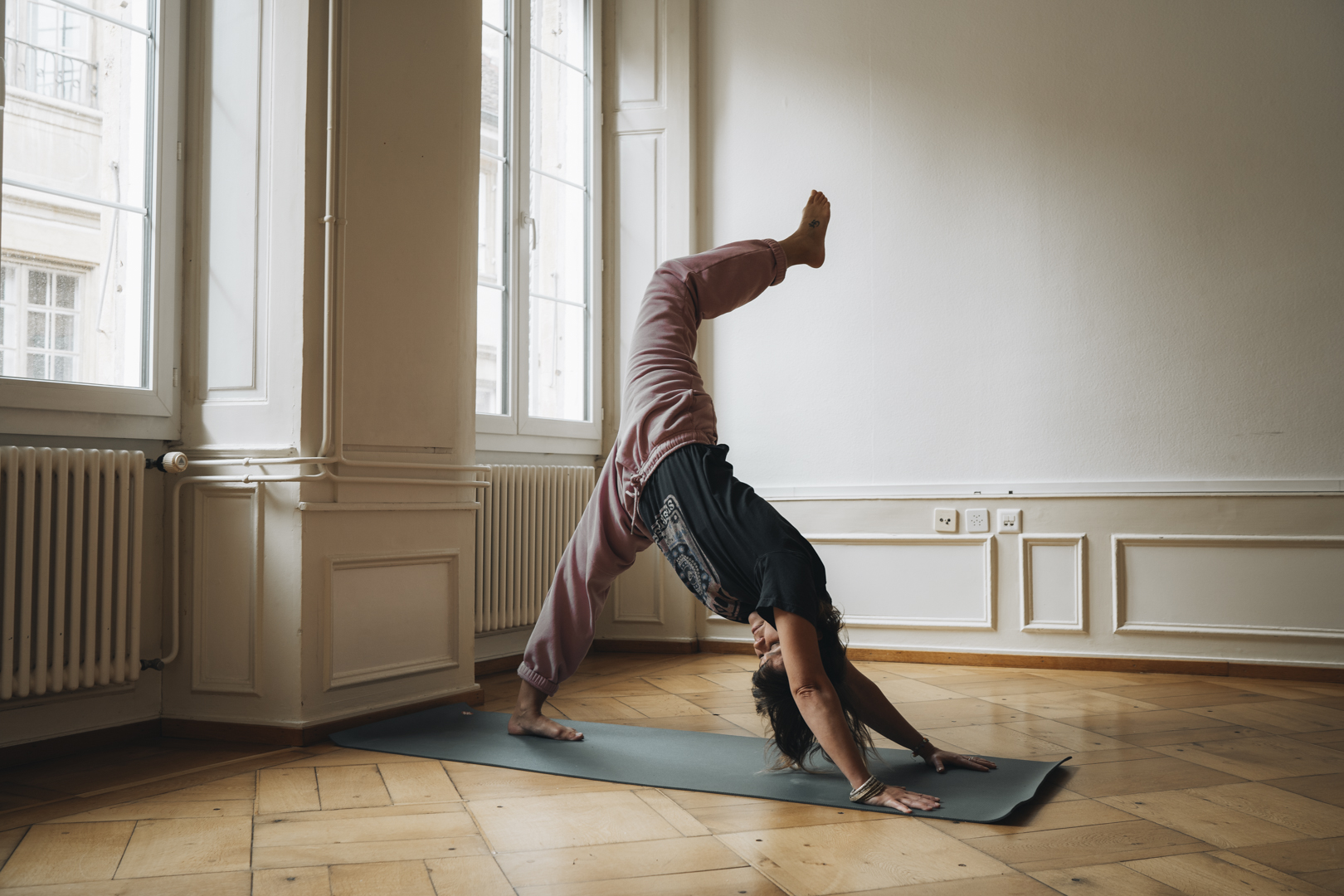 posture de yoga chien tête en bas avec une jambe levée dans un studio lumineux