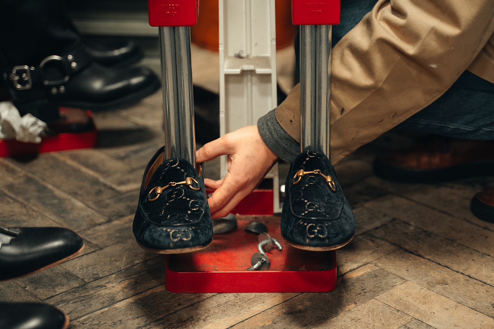 Réparation de chaussures en cuir dans une cordonnerie à Neuchâtel, gros plan sur un outil de remise en forme utilisé par un artisan.