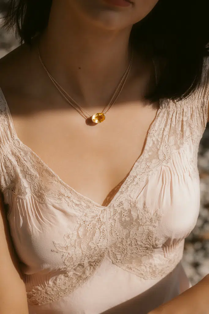 Gros plan sur le collier doré Diane Gem’s by Alice Leloir capturé par Sarah Adatte dans une lumière naturelle
